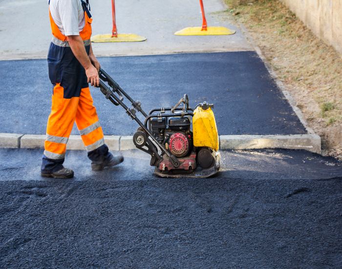 Driveways 2Day worker in Frederick, MD paving an asphalt driveway carefully to avoid mistakes